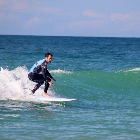 Surfista recorriendo una ola con una tabla de espuma