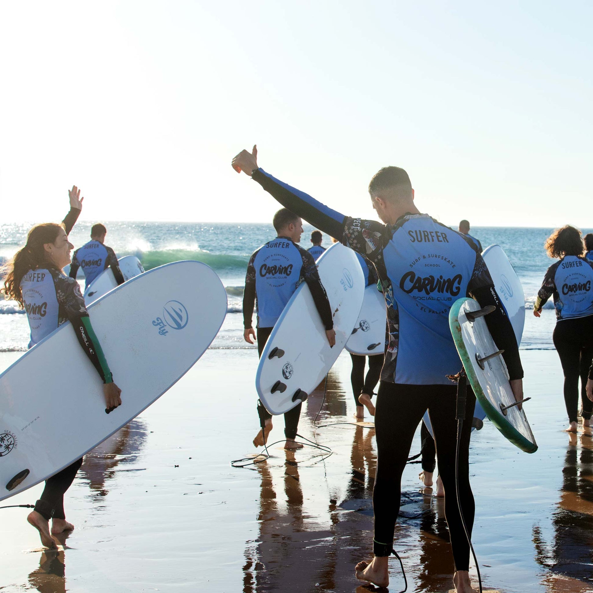 Alumnos de Carving Social Club entrando al agua en la playa de El Palmar.