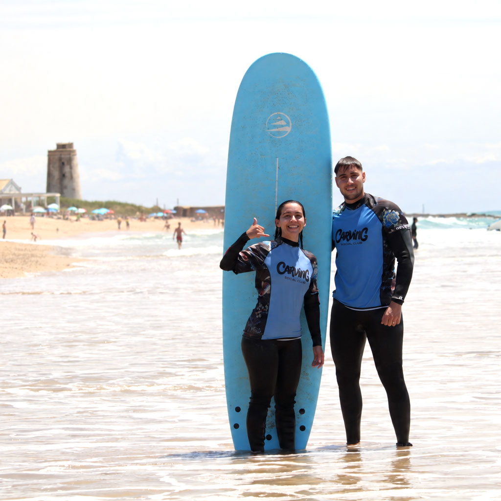 Pareja preparada para entrar al agua con sus tablas de surf
